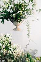 Elegant floral arrangement displayed in a classic vase with greenery photo