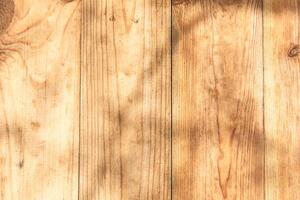 Natural wood surface with shadows highlighting texture and grain patterns in sunny light photo