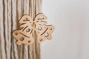 Wooden bell ornament displayed on a textured wall adding charm to holiday decorations photo