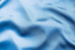 Silky blue fabric draped to showcase smooth texture and color depth photo