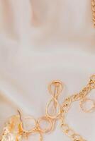 Golden jewelry accessories arranged on soft fabric background for elegant display photo