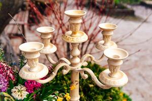 Elegant candlestick displayed amidst vibrant flowers in a garden setting during springtime photo