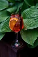 Aperol spritz cocktail with lemon and ice on a dark background. photo