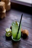 Kiwi juice in a glass with ice and fresh kiwi photo