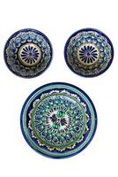 Ceramic dishes featuring intricate geometric and floral patterns. The largest dish is decorated with concentric circles and repeating motifs in blue, green, and white, accented with red and black. photo