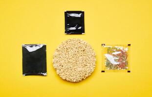 Instant noodles set on yellow photo