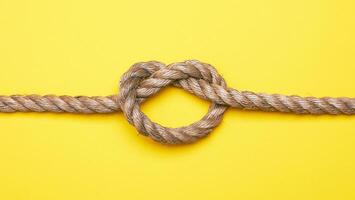 Rope with a knot on yellow photo