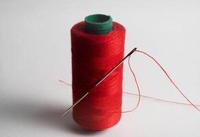 red thread spool with needle confection photo