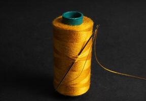 single golden thread spool with needle photo