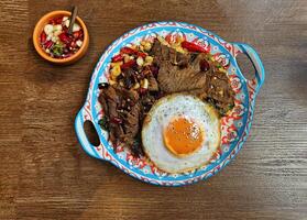 Top view of Stir fried beef with basil and dried chili paste over white rice with Thai fried egg on table photo