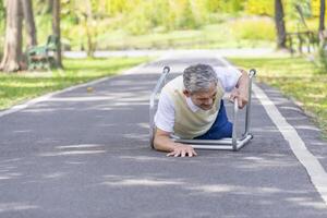 old man falling down on pathway alone in the park while try to walk with walker,senior rehabilitation,risk management,accident,fall in elderly photo