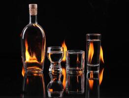 A bottle of vodka, a glass and a shot glass photo