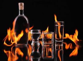 A bottle of vodka and two glasses on a black background photo