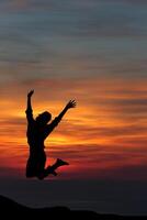 A person jumping in the air at sunset photo