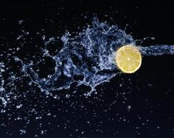 A lemon being splashed with water photo