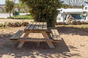 Empty gray wooden table on the green plants background with motorhome photo