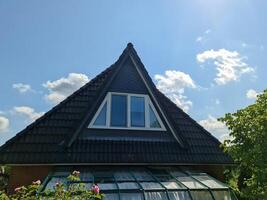 Triangular skylight window illuminating attic room under black rooftop photo
