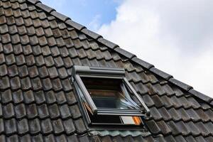 Open roof window is letting fresh air into the attic photo