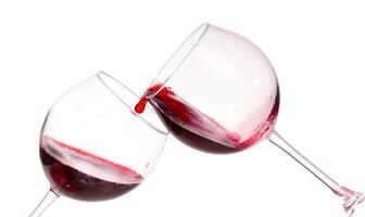 Two wine glasses with red liquid being poured into them photo