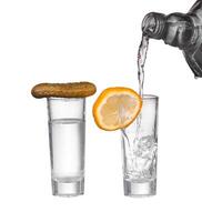 A shot glass with a slice of lemon and a shot of vodka photo