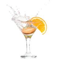 A martini with an orange slice and water splashing photo