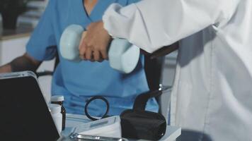 A doctor is working on a laptop while a patient is sitting at a desk video