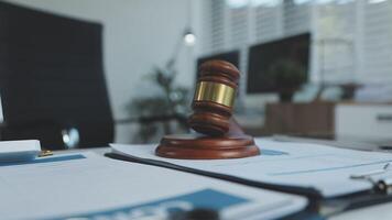 Judge's gavel on a desk with papers and laptop video