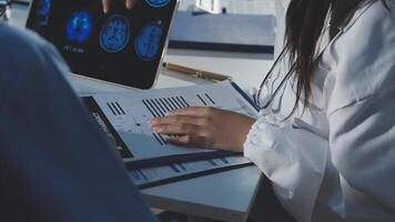 A doctor is looking at a paper with a mri image on it video