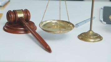 A gavel and scales on a desk with a laptop and a pen video