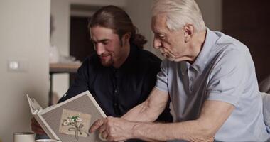 Father and son examining photos together video