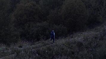 Unrecognizable man running on hilly terrain in evening time video