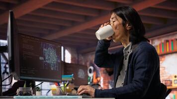 CTO manager in AI startup drinking coffee while coding applications in programming languages. Chief technician officer enjoying hot beverage and doing code testing and quality assurance, camera B photo