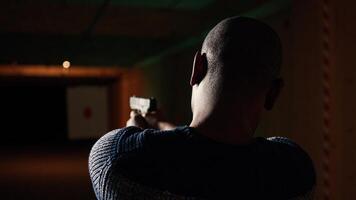 Shooting gallery customer using pistol to hit paper targets with ammo. Close up shot of man at professional firing range, shooting bullseyes, enjoying using weapons, camera A photo