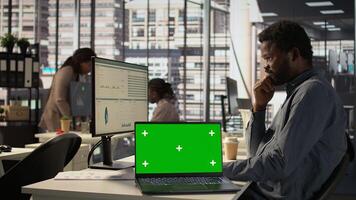 Male general manager looking at mockup screen and solving tasks for enterprise objectives achievement. Fighting for performance goals to ensure successful corporate outcomes for firm. Camera B. photo