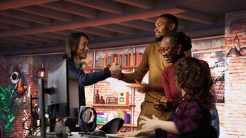 Startup team cheering after seeing live market updates showing stocks raising, doing high five. Joyous venture staff members overjoyed after becoming publicly traded company, camera B photo