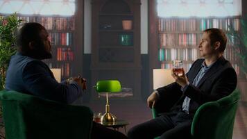 Elegant old money gentlemen in refined upper class library meeting to discuss business, agreeing on partnership with dapper style in luxury social club environment. Estate heirs. Camera A. photo