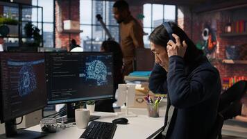 CTO manager in artificial intelligence focused startup, drinking coffee and listening to music, debugging applications. Asian technician putting headphones on, doing code testing, camera A photo