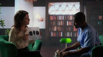 Counselor presenting Rorschach test to medical assistant in uniform, looking for answers with psychoanalysis illustration. Nurse suffering from PTSD and trauma, interpretation therapy. Camera A. photo