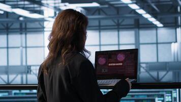 Cybersecurity expert in data center frantically trying to counter hacker attack. Server room worker under pressure to secure sensitive information after threat alert received on laptop, camera A photo