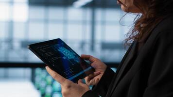Engineer in with tablet integrating AI driven automation tools. Worker ensuring continuous uptime of server room using artificial intelligence, managing data flows, camera A photo