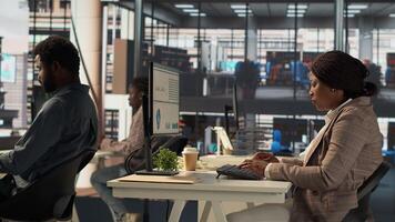 Skilled female investor working on financial forecasts at workstation, using monthly infographics data to manage business tasks for enterprise development. Company goals. Camera A. photo