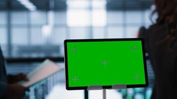 Focus on chroma key device in front of technicians analyzing metrics. Close up of isolated screen tablet next to server hub workers ensuring seamless operations, camera A photo