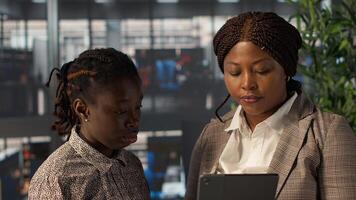 Black manager reviewing company strategy with female assistant in corporate office, making key business decisions to support organizational growth. Discussing resource allocation. Camera A. photo