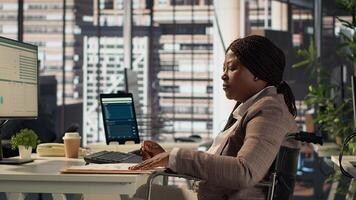 Female boss with disability examining archived files and data reports, creating financial plan before allocating resources. Businesswoman in wheelchair reviews infographics. Camera A. photo