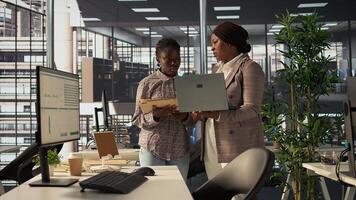 Professional team analyzing archived data on laptop, collaborating on enterprise solutions and financial planning tasks to improve company performance and for long term growth. Camera B. photo