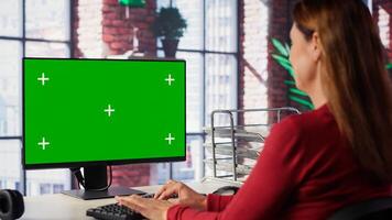 Independent person using computer with green screen for remote job tasks, surrounded by notes and enjoying benefits of schedule flexibility. Modern lifestyle. Camera A. photo