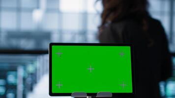 Close up of chroma key tablet and programmers in server room adjusting power management settings. Focus on isolated screen mockup device in front of data center technicians, camera A photo
