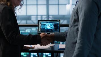 Manager meeting with client in data center using artificial intelligence tech, reaching deal. People handshaking in AI based server farm after checking files and finishing transaction, camera A photo