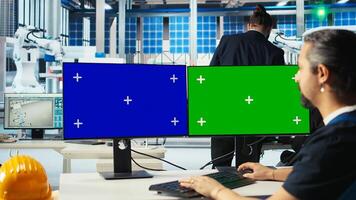 Smart manufacturing plant expert develops solar energy prototypes using green screen computer displays. Man researching new photovoltaics materials using chroma key PC monitors, camera A photo