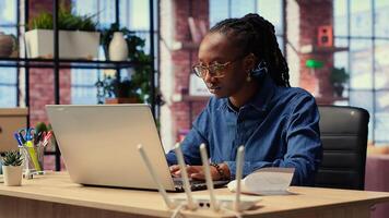 Irritated African American girl struggles in reaching internet provider to help fix signal loss, freelancer working at home with unstable Wi Fi connection. Camera B. photo
